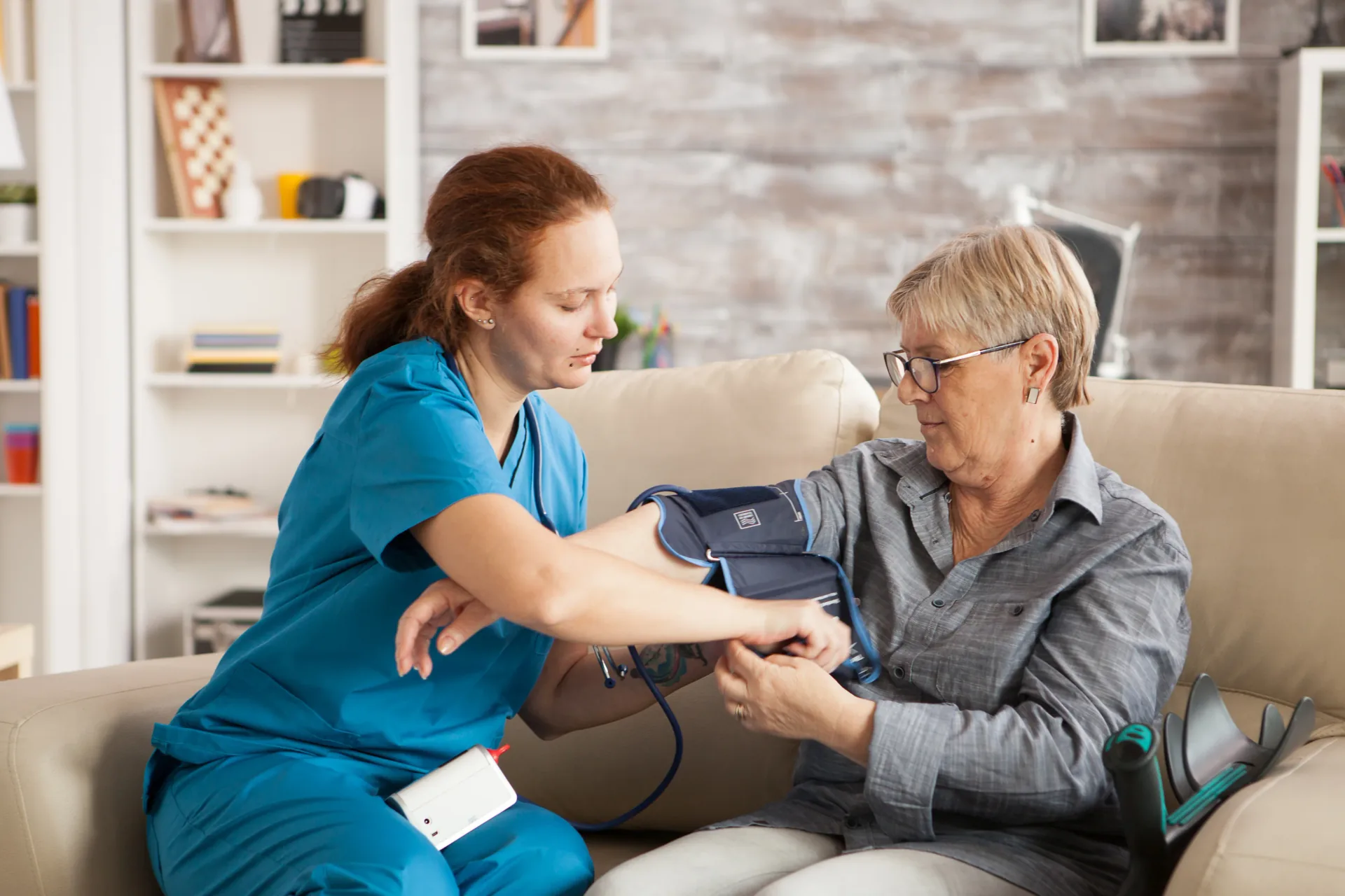 Nurse checking an older person's blood pressure at home