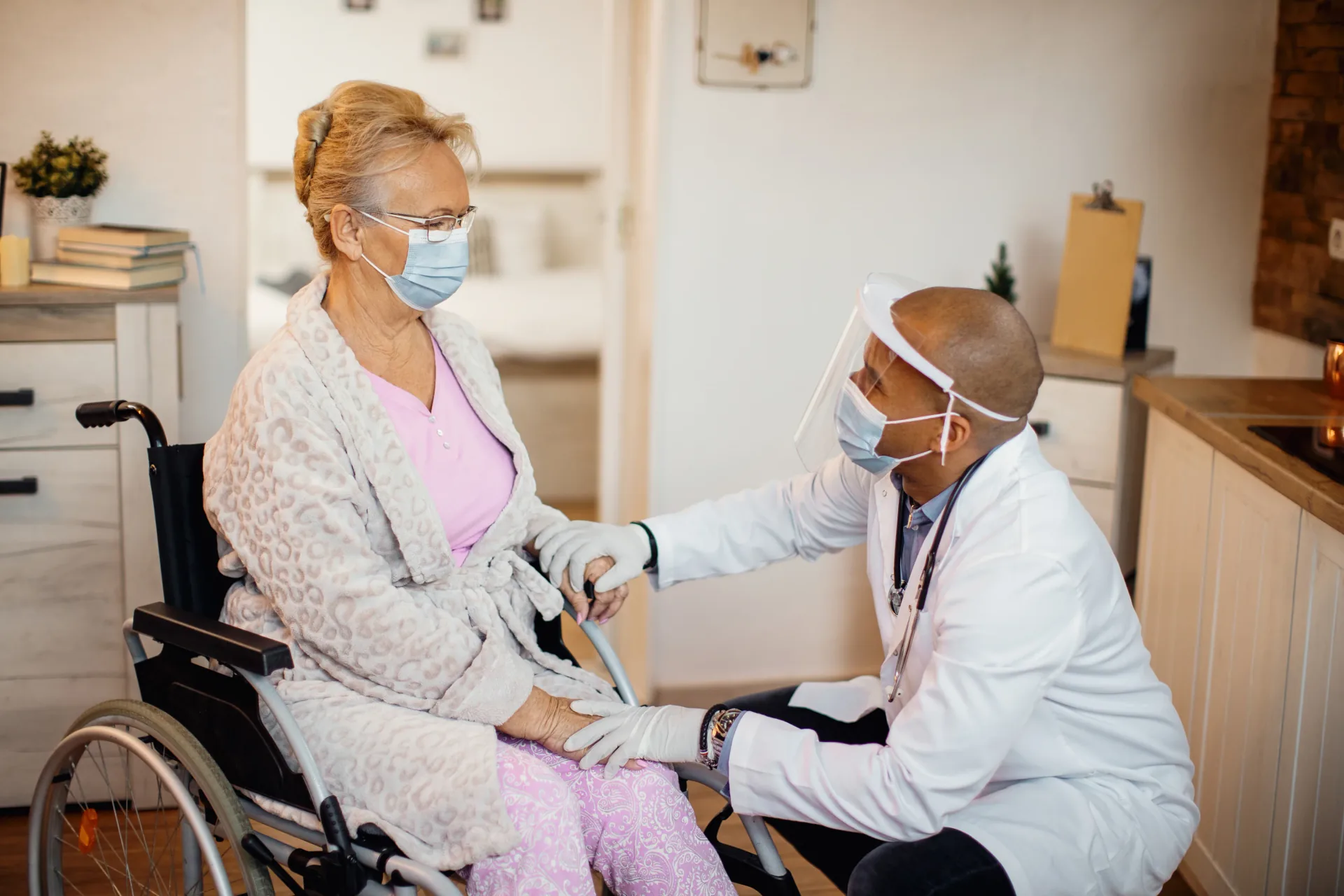 Healthcare worker supporting an older adult in a wheelchair